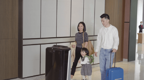 Robot d'hôtel FlashBot de Sebotics avec une jeune famille