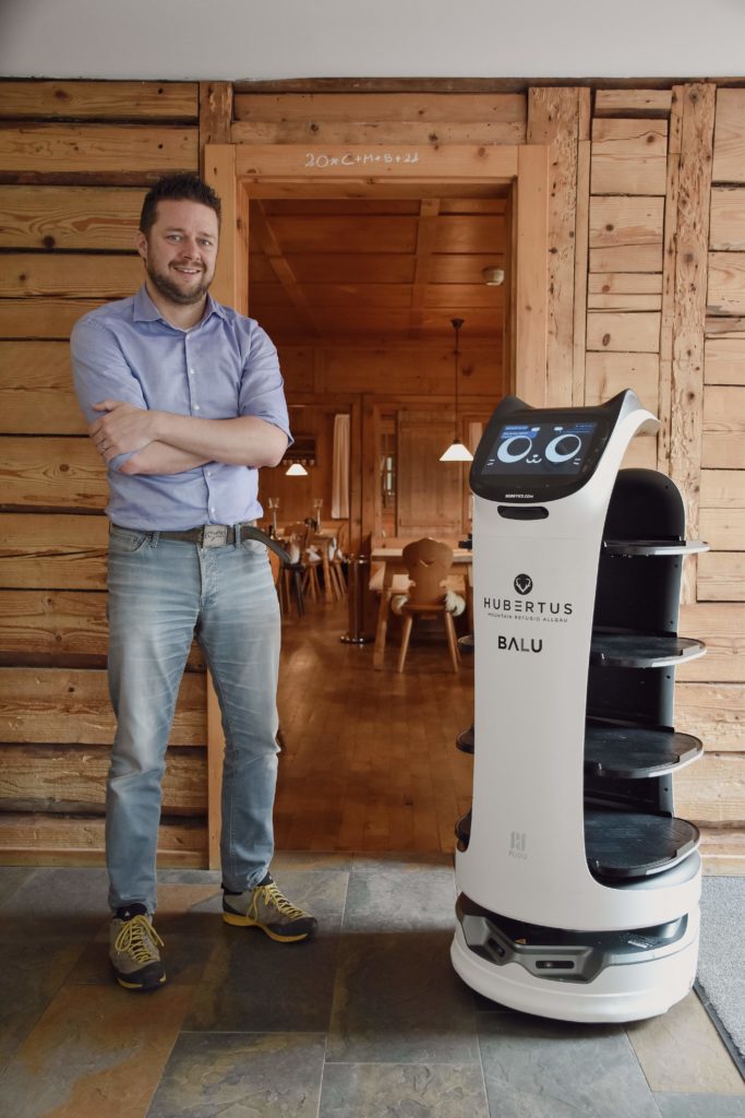 Hotel Hubertus Mountain Refugio owner Marc Traubel with the service robot BellaBot from Sebotics