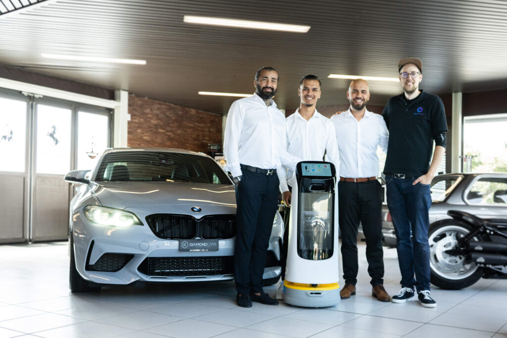 Diamond Cars AG Team und Emanuel von Sebotics mit dem KettyBot